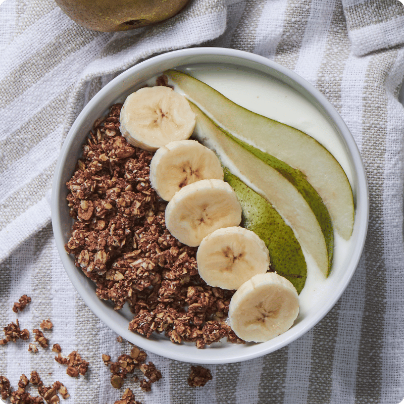Bohlsener Mühle Knuspriges Müsli mit Bananen und Birnen in einer Schüssel.