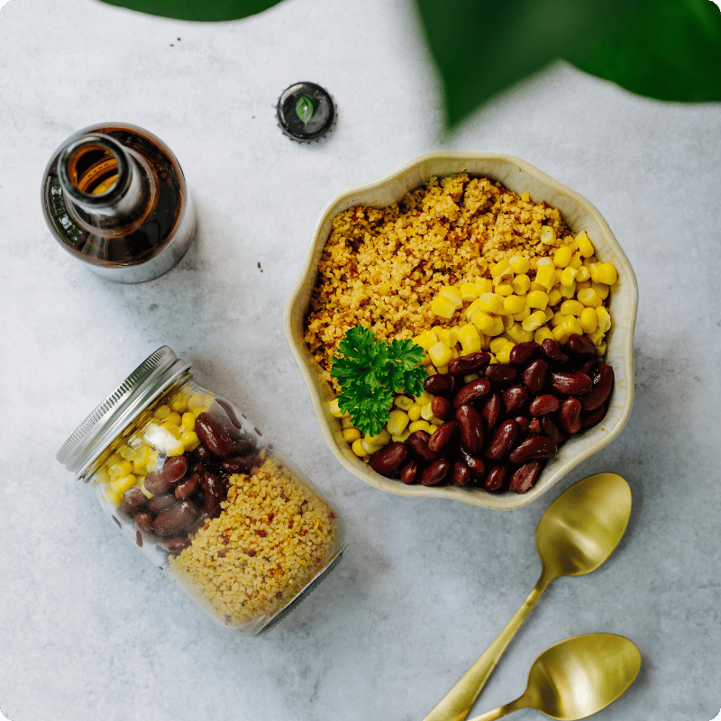 Bohlsener Mühle Couscous mit Mais, roten Bohnen und Petersilie in einer Schüssel.