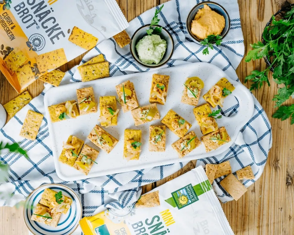 Bio-Snacks der Bohlsener Mühle, darunter Brot, Müsli und knusprige Häppchen.