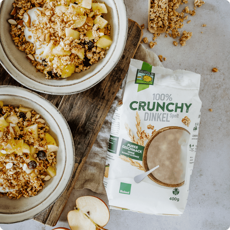 Zwei Schalen mit Bohlsener Mühle Crunchy Dinkel und frischem Obst.