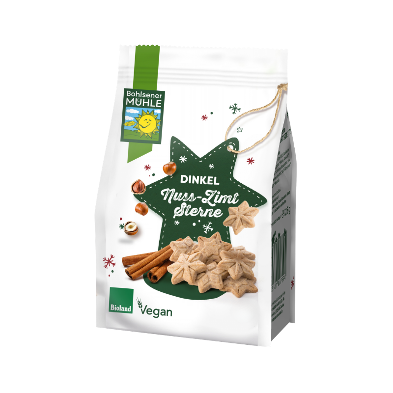 Bohlsener Mühle Dinkel Nuss-Zimt Sterne Cookie Packung mit Haselnüssen und Zimtstangen auf weißem Hintergrund.