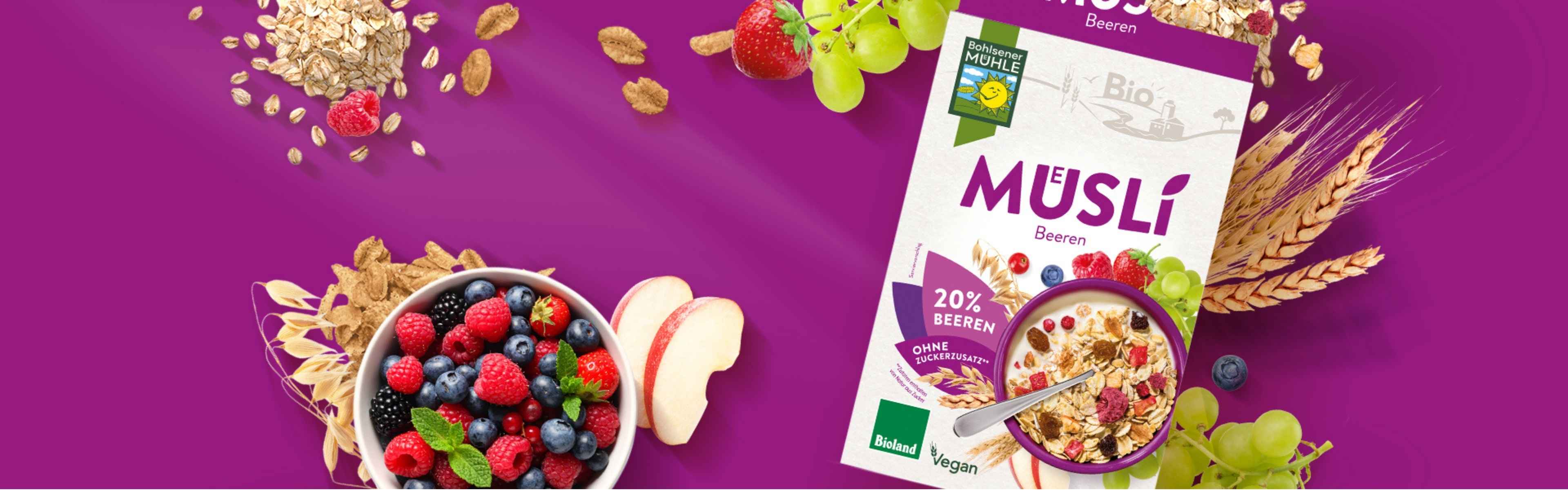 Bohlsener Mühle Müsli mit Bieren, frischen Früchten und Haferflocken auf lila Hintergrund.