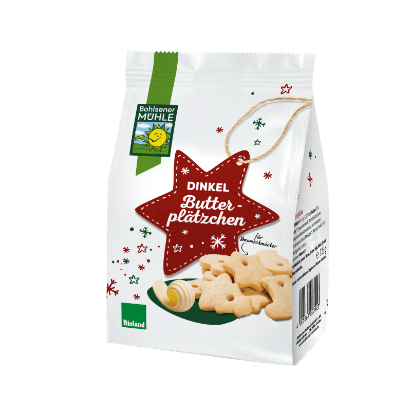 Eine Packung Dinkel Butterplätzchen der Bohlsener Mühle mit weihnachtlichem Stern-Anhänger und ausgestochenen Keksen.