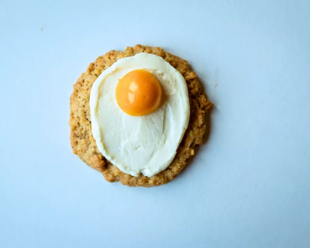 Bohlsener Mühle Keks mit Creme Topping und Pfirisch, angerichtet wie ein Spiegelei.