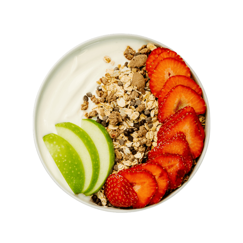 Bohlsener Mühle Crunchy Cookie Müsli in einer Schale mit Joghurt, Erdbeerscheiben und grünen Apfelspalten.