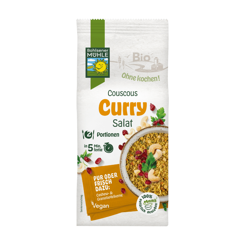 Bohlsener Mühle Couscous Curry Salat in einer Schüssel mit Cashewkernen und Granatapfelkernen.