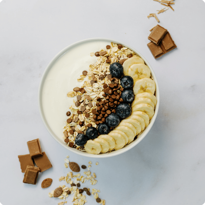 Bohlsener Mühle Joghurt mit Bananen, Heidelbeeren, Schokolade und Haferflocken.