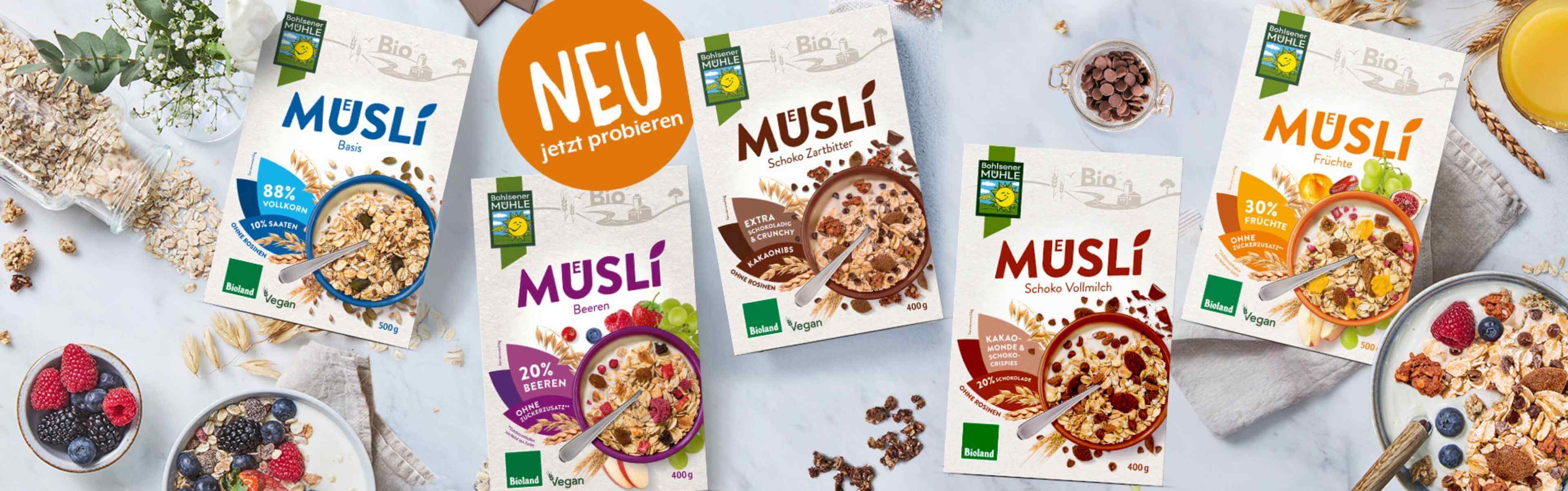 Bohlsener Mühle Müslis in verschiedenen Sorten mit Früchten und Schokolade auf einem Tisch.