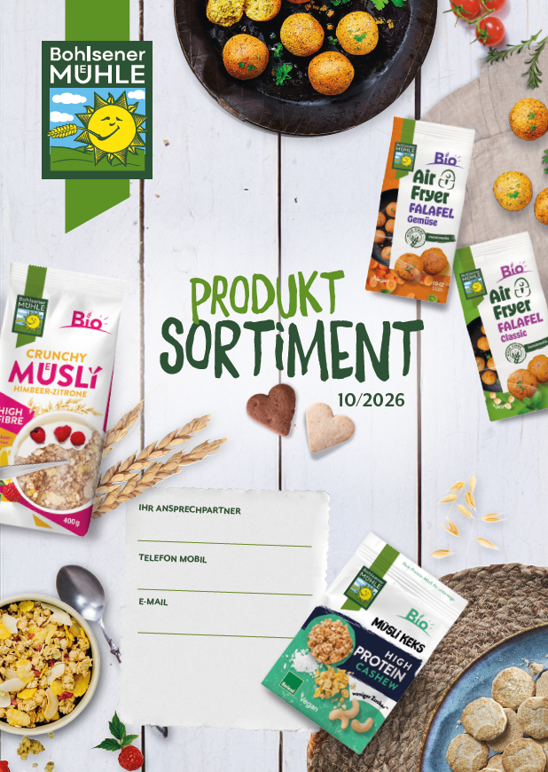 Bohlsener Mühle Produktsortiment mit Müsli, Falafel und Müsli Keks Cookie auf einem hellen Holztisch arrangiert.