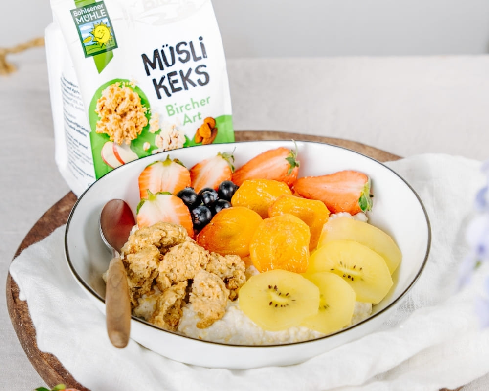 Schüssel mit Müsli Keks von Bohlsener Mühle, frische Früchte und Joghurt.