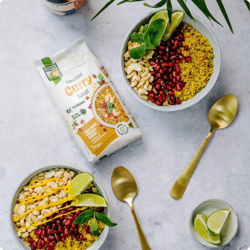 Bohlsener Mühle Couscous Curry Salat mit frischen Zutaten in Schalen.