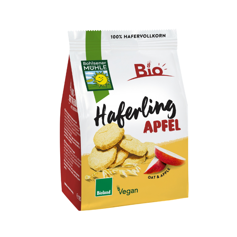 Bohlsener Mühle Haferling Apfel Cookie Packung mit Haferkeksen und frischen Apfelstücken auf gelbem Untergrund.
