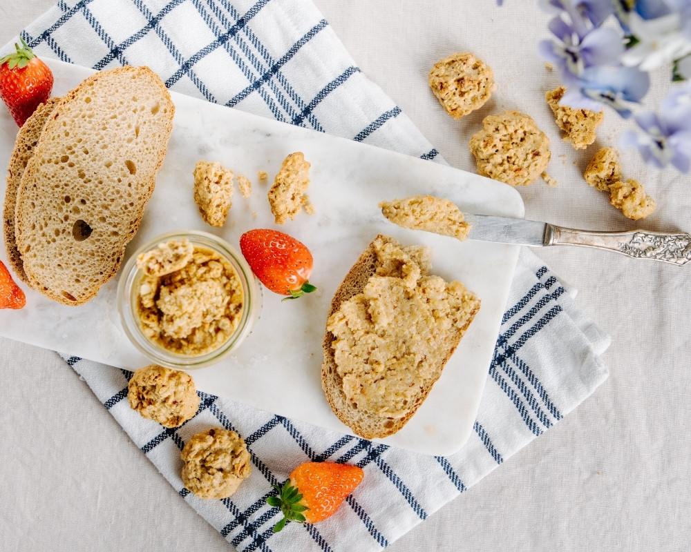 Bohlsener Mühle Cookie Aufstrich auf Brot mit Erdbeeren und Keksen.