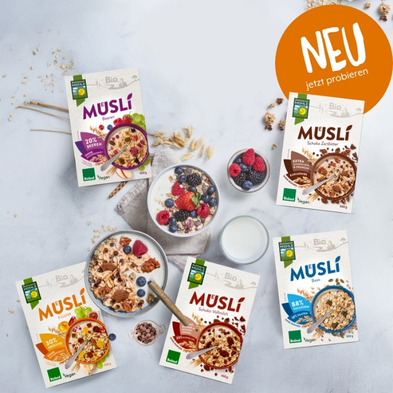 Bohlsener Mühle Müslis in verschiedenen Sorten mit Früchten und Schokolade auf einem Tisch.