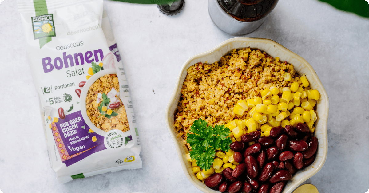 Bohlsener Mühle Couscous Bohnen Salat in einer Schüssel mit Mais, roten Bohnen und Petersilie.