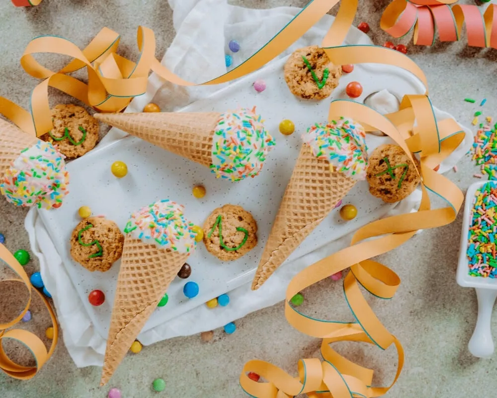 Bohlsener Mühle Bio-Dinkel-Vollkorn-Tiercracker, Eiswaffeln mit Streuseln und Kekse auf einem weißen Tuch.