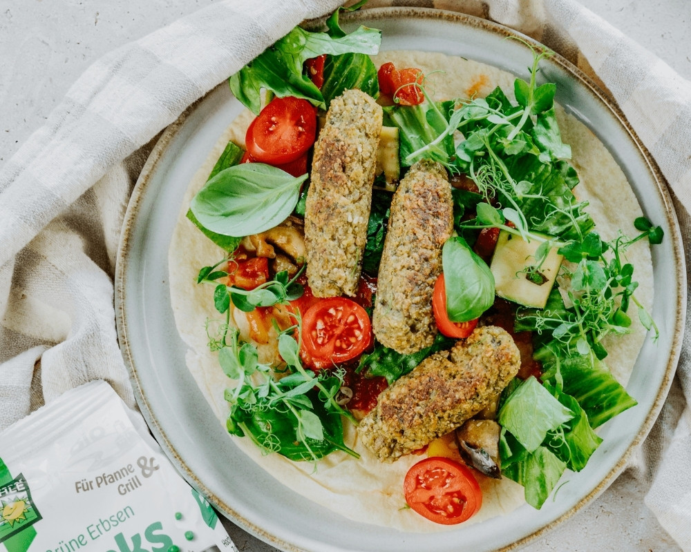 Bohlsener Mühle grüne Erbsen-Crunchy auf einem Salat-Teller mit frischen Zutaten.