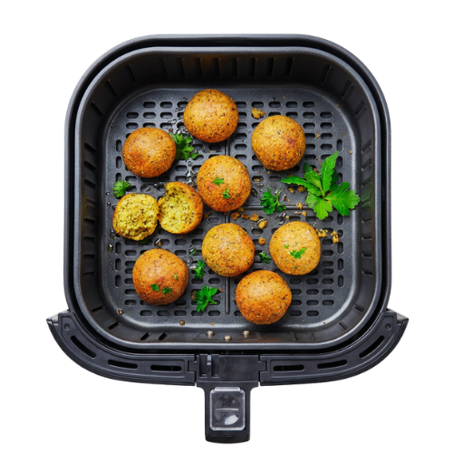 Bohlsener Mühle Falafel Bällchen liegen mit frischer Petersilie in einem schwarzen Heißluftfritteusen-Korb.