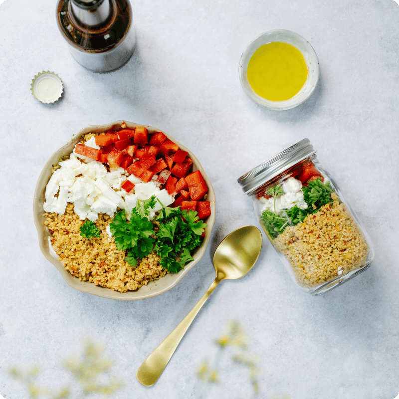 Bohlsener Mühle Couscous-Salat mit Paprika, Feta und frischen Kräutern in einer Schüssel.