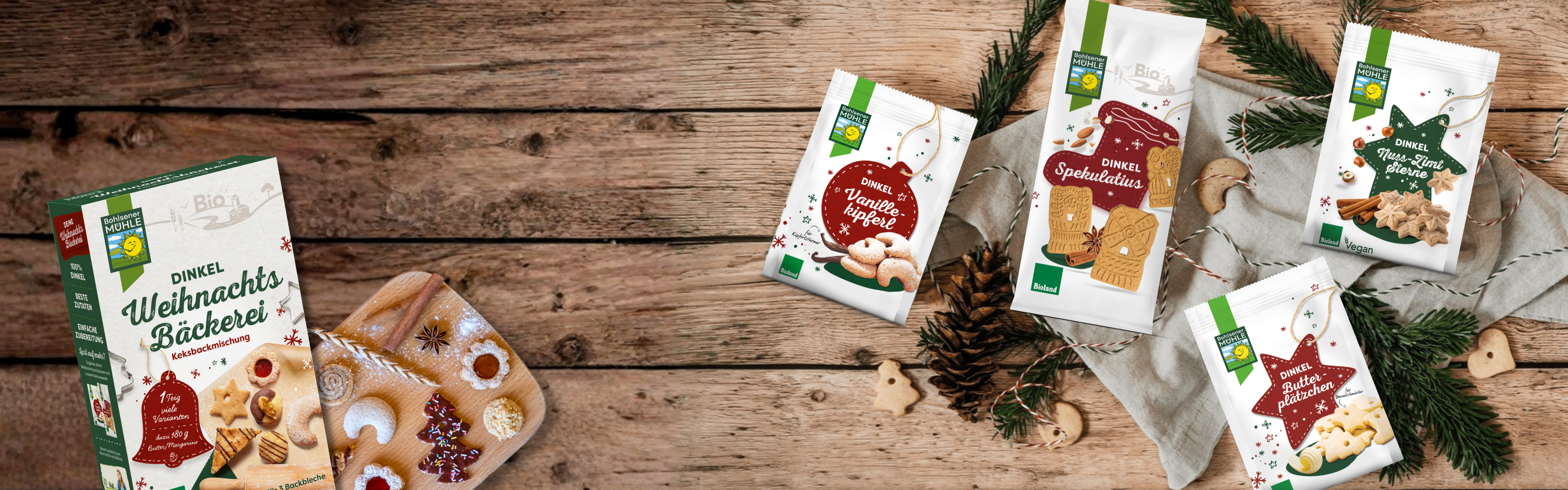 Bohlsener Mühle Dinkel Weihnachts-Bäckerei und verschiedene Keks-Sorten auf einem rustikalen Holztisch arrangiert.