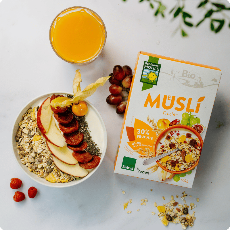 Bohlsener Mühle Müslischale mit Früchten, Chiasamen und Saftglas.