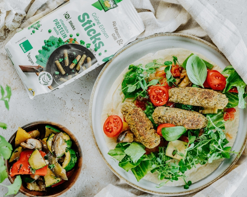 Bohlsener Mühle Grüne Erbsen Sticks auf einem frischen Salat mit Tomaten.