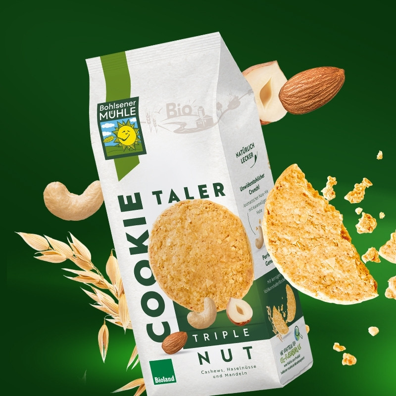 Bohlsener Mühle Kekstaler mit Nüssen und Haferkeksen auf grünem Hintergrund.