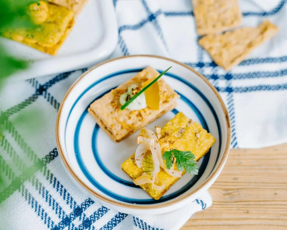 Bio Mini Snäckebrot von der Bohlsener Mühle mit knusprigen Crackern und verschiedenen Toppings für nachhaltigen Genuss.