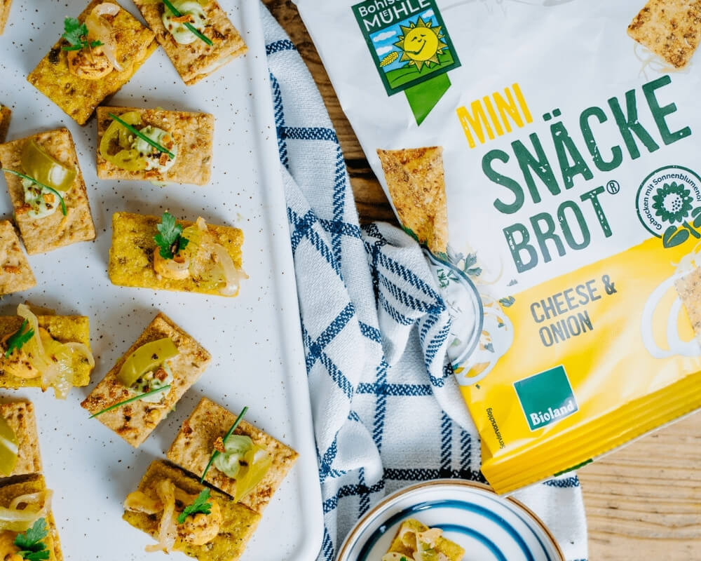 Bohlsener Mühle Mini-Snäckebrot, Käse-Zwiebel-Geschmack, Bio, mit Belag, als Sandwich.