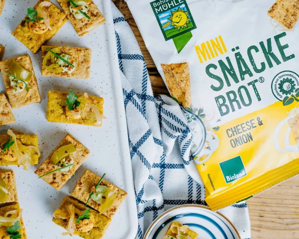 Bohlsener Mühle Mini-Snäckebrot, Käse-Zwiebel-Geschmack, Bio, mit Belag, als Sandwich.