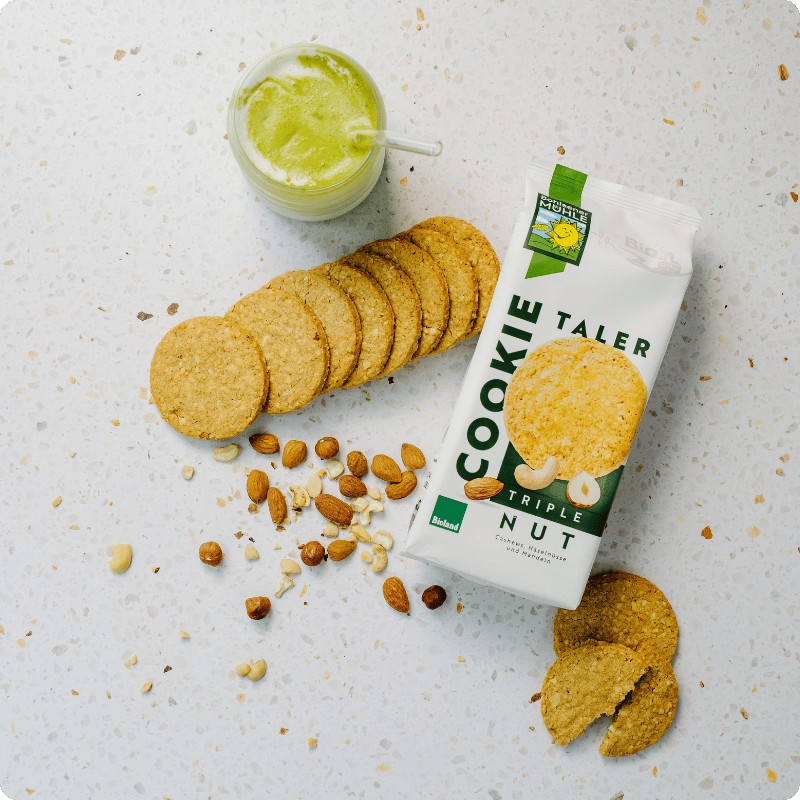 Bohlsener Mühle Cookie Taler Triple Nut mit Nüssen und einem grünen Smoothie.