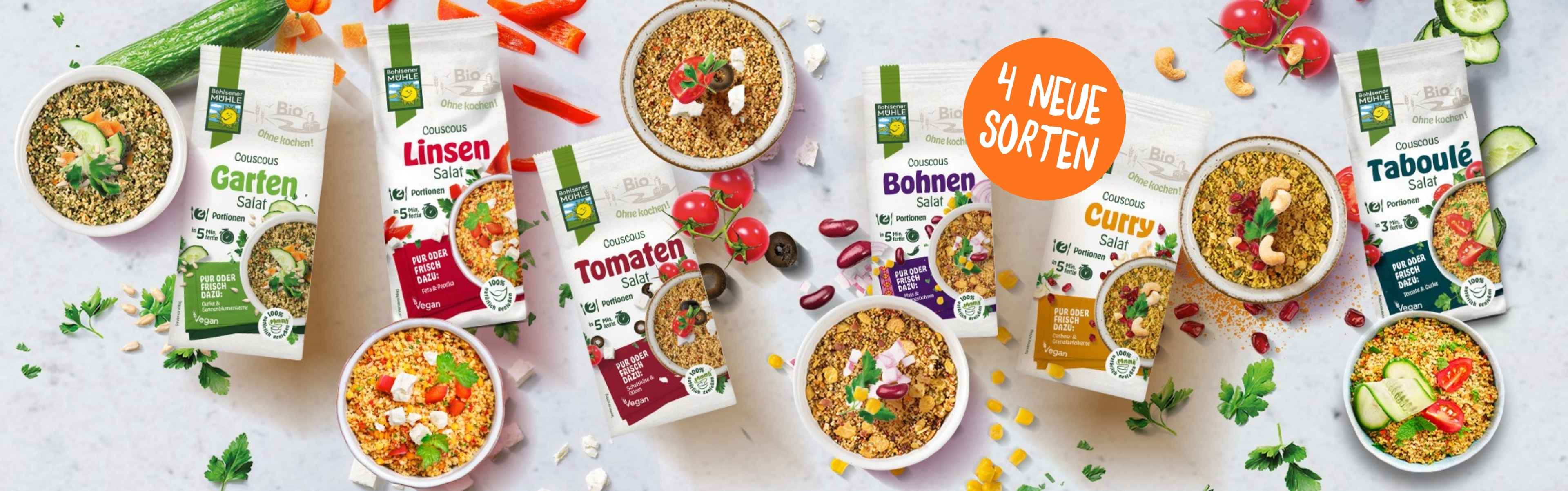 Verschiedene Couscous Salate von Bohlsener Mühle in Schalen und Verpackungen.