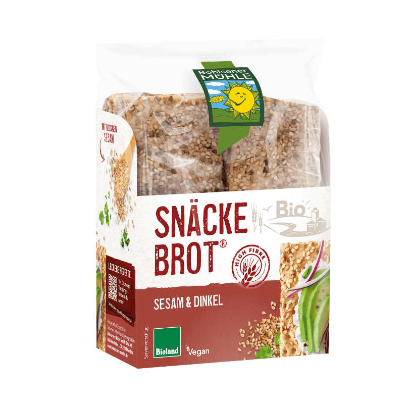 Eine Packung Bohlsener Mühle Snäcke Brot Sesam & Dinkel mit sichtbaren Knäckebrot-Scheiben und Avocado-Belag.