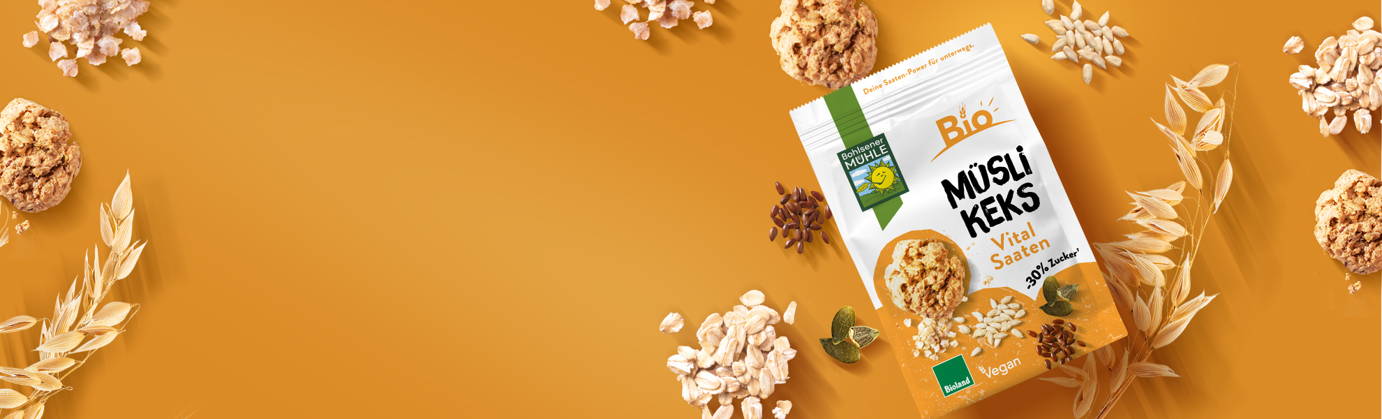 Bohlsener Mühle Müsli Keks Vital Saaten umgeben von Haferflocken, Saaten und weiteren Crunchy Cookies auf gelbem Grund.