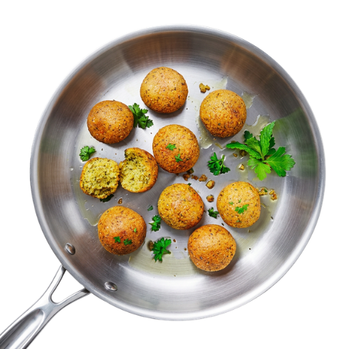 Bohlsener Mühle Falafel Bällchen in einer silbernen Pfanne mit frischer Petersilie und etwas Öl angerichtet.