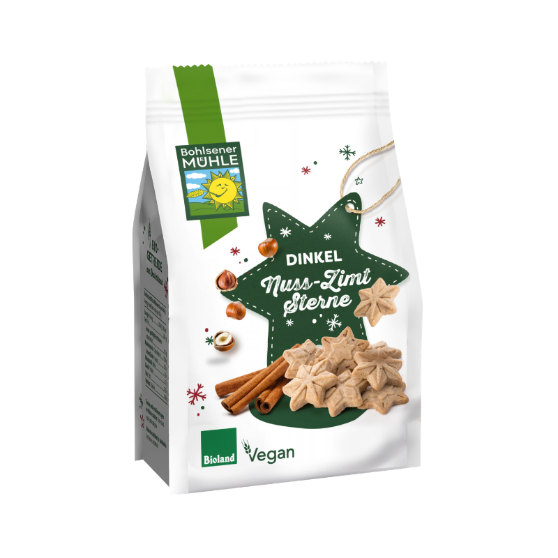Bohlsener Mühle Dinkel Nuss-Zimt Sterne Cookie Packung mit Zimtstangen und Haselnüssen auf weißem Hintergrund.