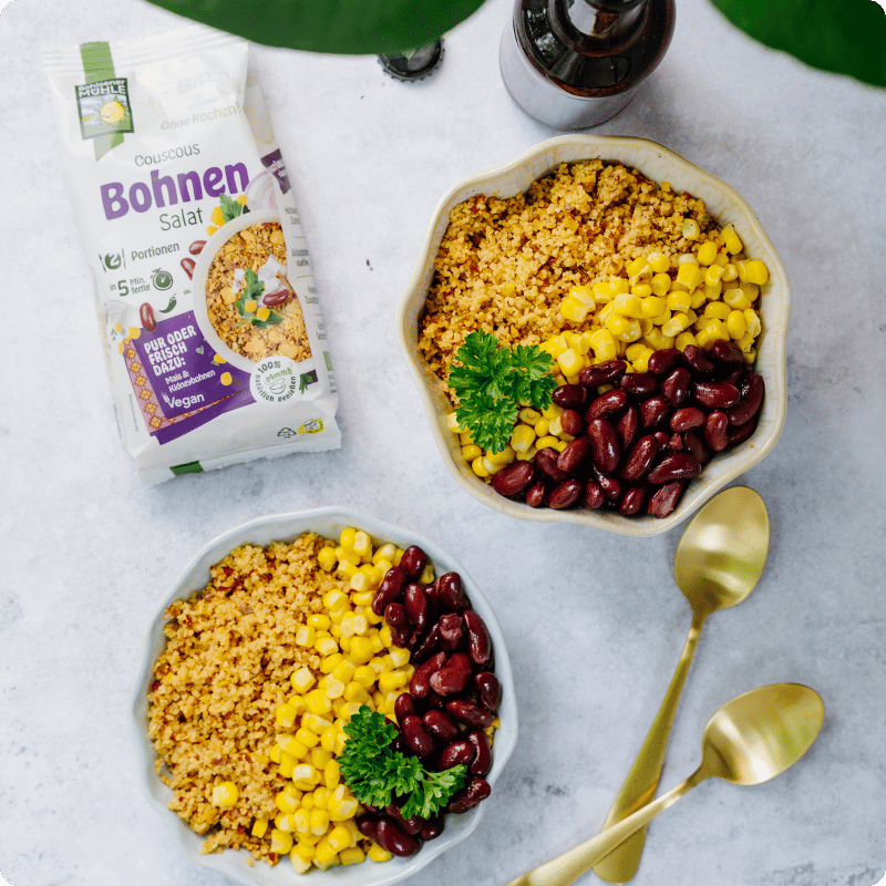 Zwei Schalen mit Bohnen-Salat, Couscous, Mais und roten Bohnen von Bohlsener Mühle.