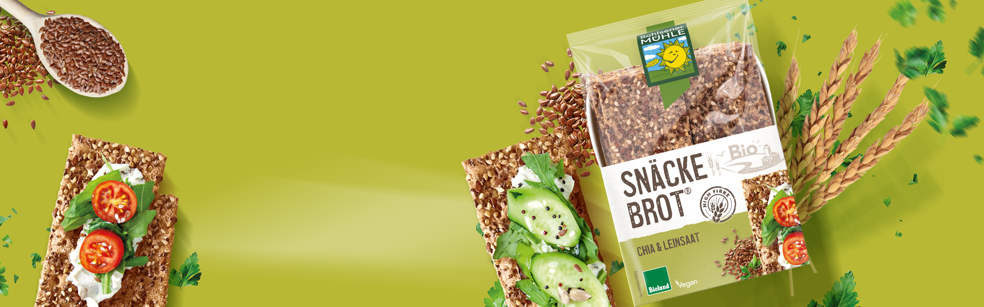 Bohlsener Mühle Snäckebrot Chia & Leinsaat mit frischem Gemüse und Kräutern auf grünem Hintergrund angerichtet.