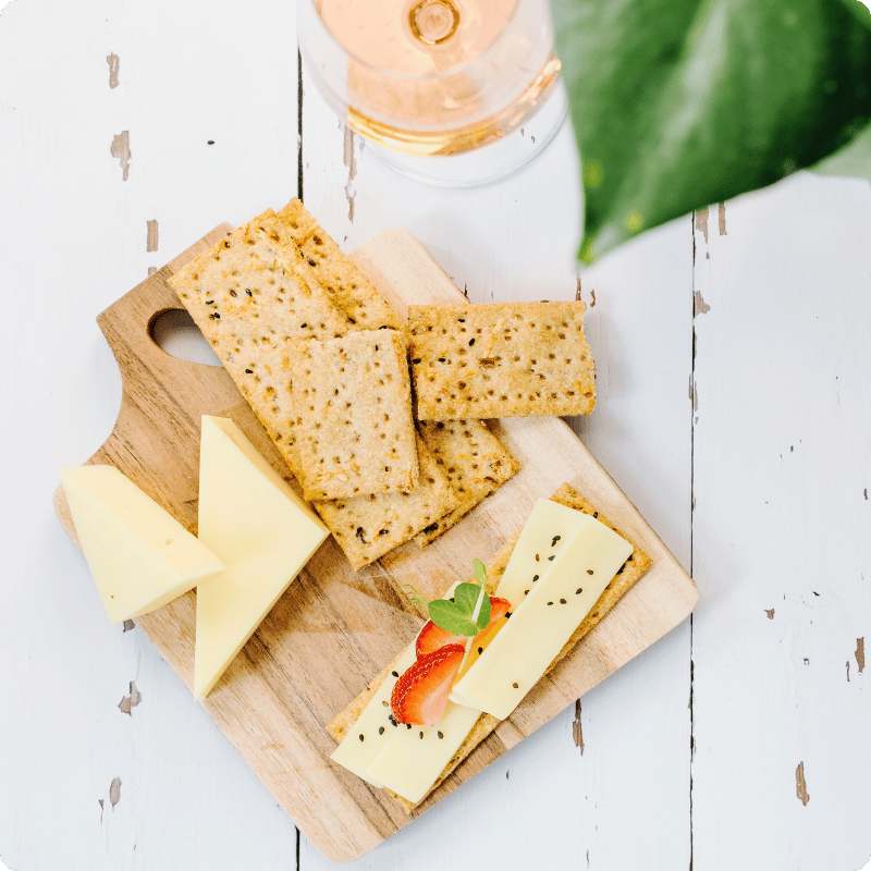 Bohlsener Mühle Käse und knusprige Cracker auf einem Holzbrett.