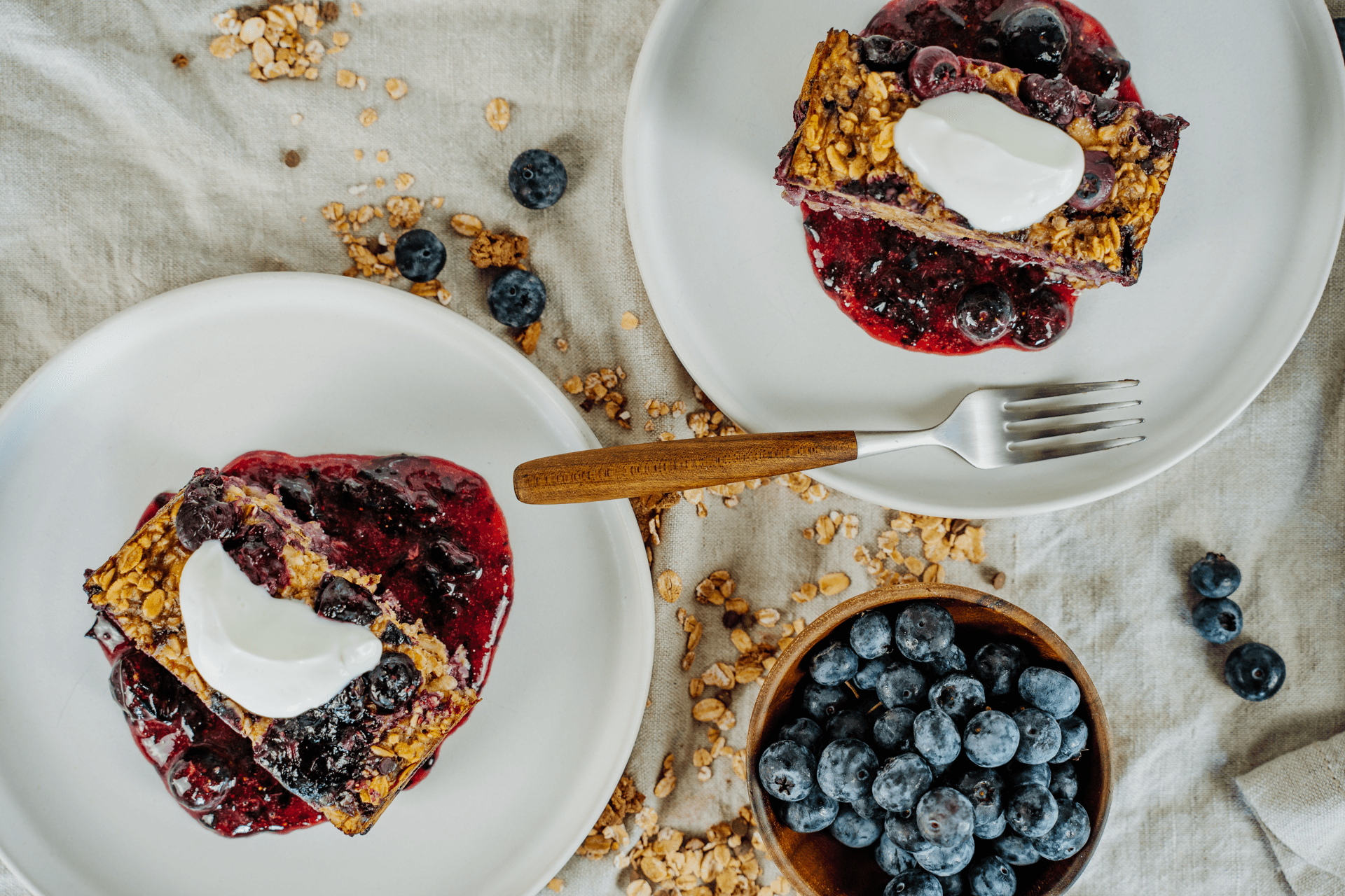 Bohlsener Mühle Blaubeer-Crunchy mit Joghurt und Beerensauce auf Tellern.
